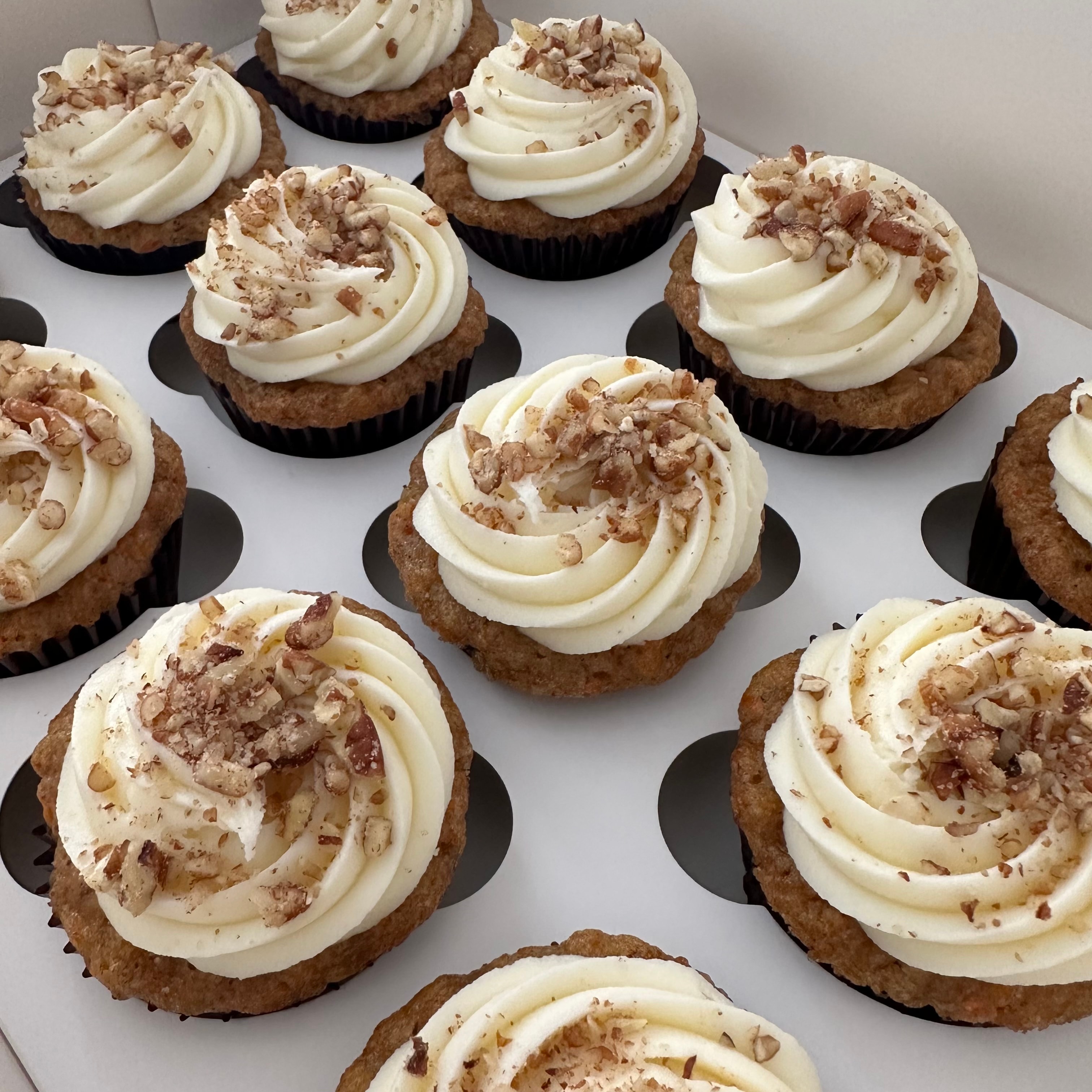 Carrot cupcakes with cream cheese frosting and pecans
