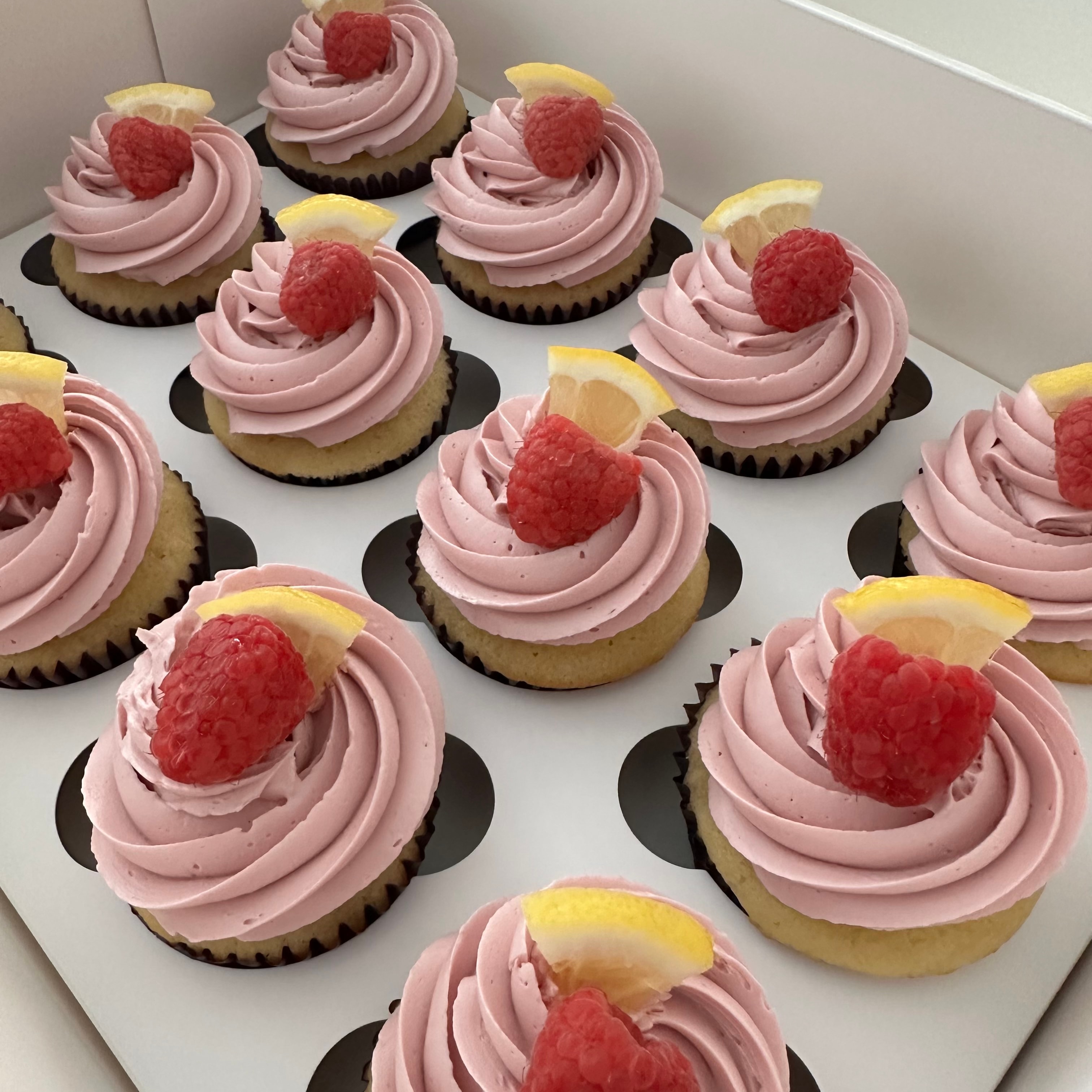 Lemon raspberry cupcakes with fresh raspberries and lemon garnish